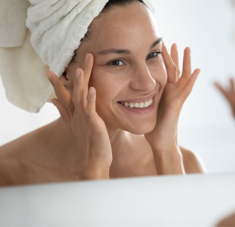 woman smiling in mirror feeling face