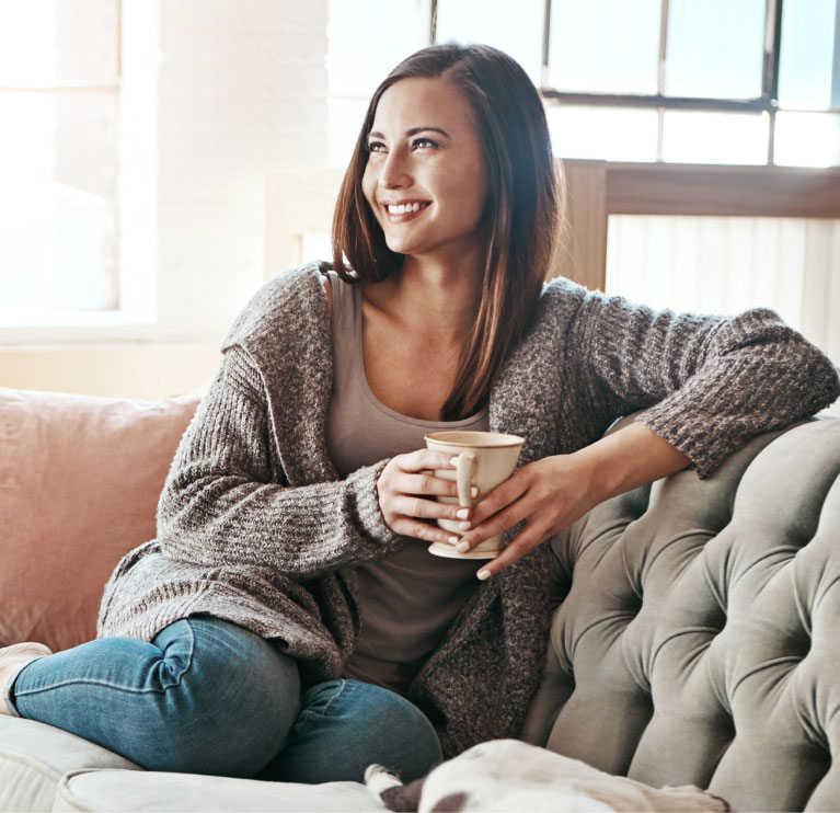 post mommy make over model on couch in sweater with coffee